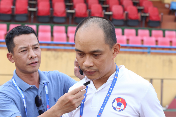 Trợ lý trọng tài Nguyễn Trung Hậu được đội ngũ ban tổ chức hỗ trợ để đeo thiết bị - Ảnh: ĐỨC KHUÊ