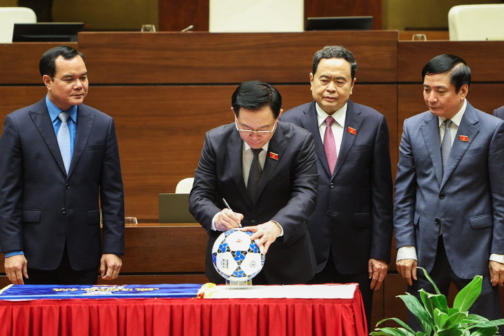 Chủ tịch Quốc hội ký tên vào quả bóng thi đấu chính thức của giải - Ảnh: NGUYỄN KHÁNH
