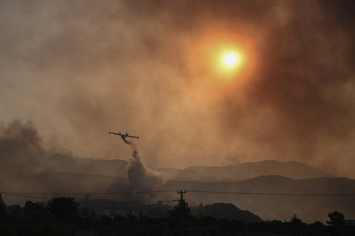 Máy bay cứu hỏa hoạt động tại đảo Rhodes hôm 25-7 - Ảnh: AFP