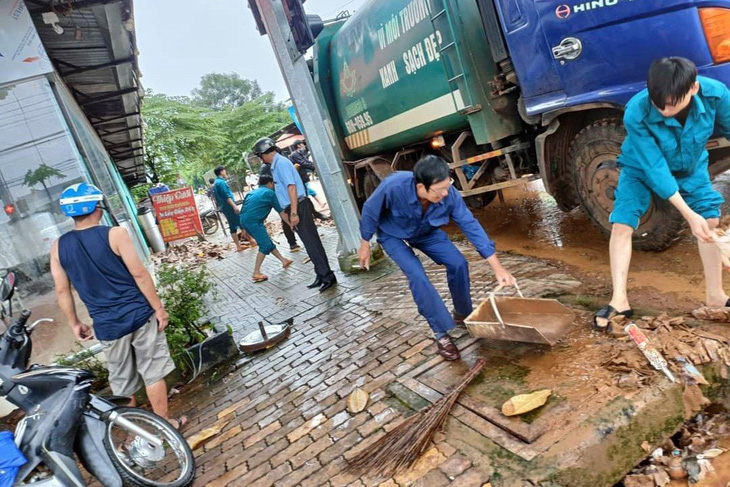 Lực lượng chức năng và người dân dọn dẹp nhà cửa, đường sá sau trận ngập lớn - Ảnh: AN BÌNH