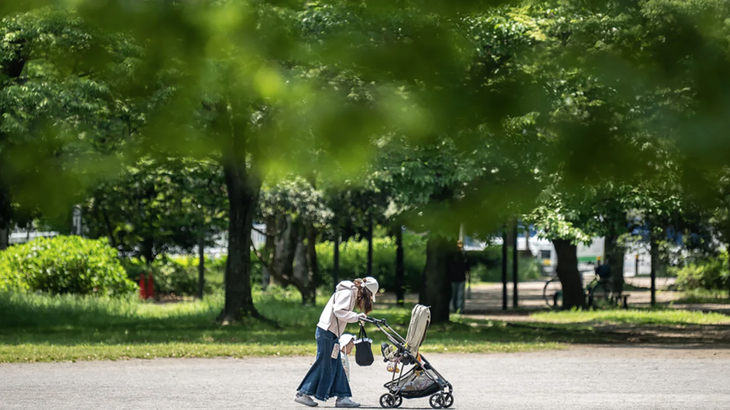 Một phụ nữ đi dạo cùng con tại công viên ở Tokyo, Nhật Bản vào tháng 5-2023 - Ảnh: CNN