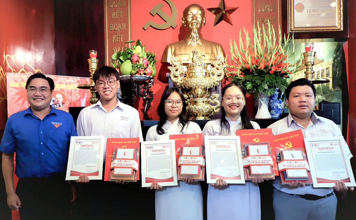 Phó bí thư thường trực Thành Đoàn TP.HCM Ngô Minh Hải (trái) tặng quà chúc mừng bốn đảng viên tuổi 18 của quận 5 vừa trở thành đảng viên trẻ tại nhà tưởng niệm Chủ tịch Hồ Chí Minh (số 5 Châu Văn Liêm, quận 5, TP.HCM) - Ảnh: K.ANH