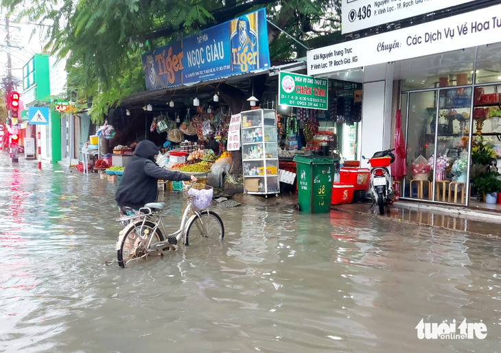 Có đường ngập sâu hơn nửa bánh xe, người dân phải dắt bộ vô nhà - Ảnh: CHÍ CÔNG