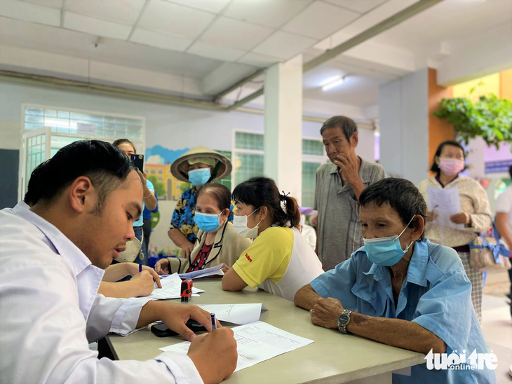 Ông Phạm Văn Mong (67 tuổi, ngụ phường Tân Thuận Tây, quận 7) được nhân viên y tế Bệnh viện quận 7 tầm soát sức khỏe - Ảnh: X.M.