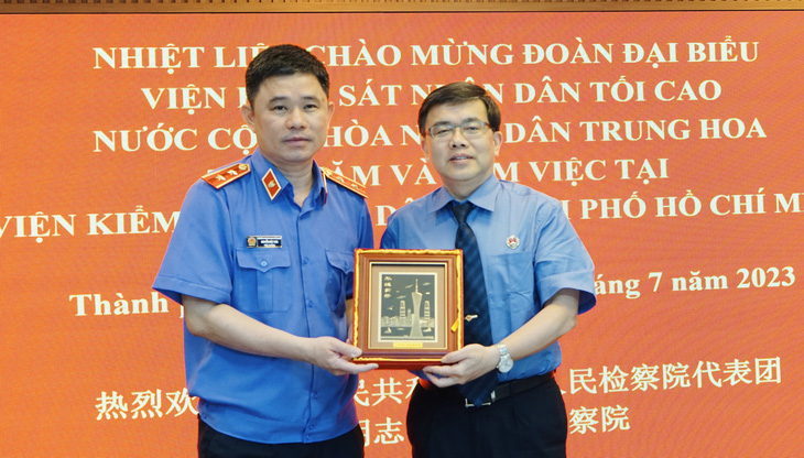 Ông Nguyễn Đức Thái, viện trưởng VKSND TP.HCM (bên trái), tặng quà và nhận quà tặng từ ông Khưu Lợi Quân, phó viện trưởng VKSND tỉnh Hải Nam, trưởng đoàn công tác - Ảnh: TUYẾT MAI