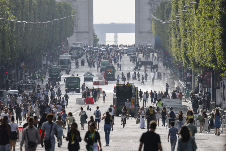 Người đi bộ trên đại lộ Champs-Elysees ở Paris, Pháp vào ngày 2-7, một ngày sau khi những người biểu tình xuống đường và đụng độ với cảnh sát trên con đường mang tính biểu tượng - Ảnh: AFP