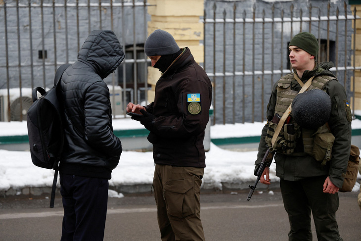 Lực lượng thực thi pháp luật Ukraine kiểm tra giấy tờ một người vào Kiev hồi tháng 11-2022 - Ảnh: REUTERS