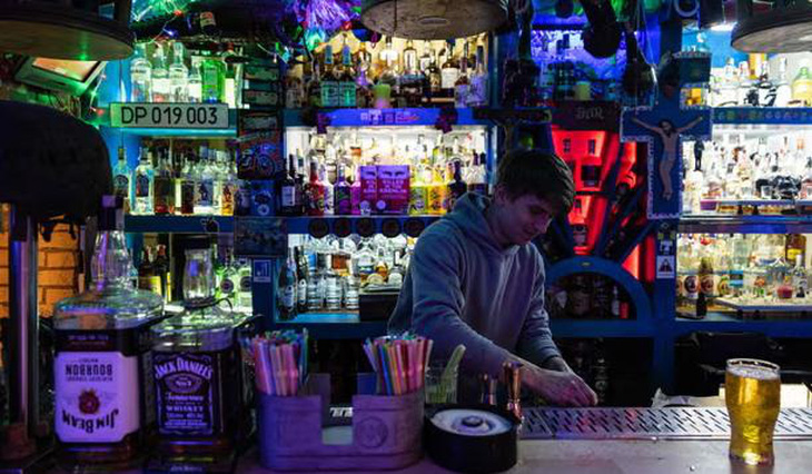 Một nhân viên pha chế trong một quán bar ở Kiev. Giờ giới nghiêm của thành phố là 11h đêm kể từ tháng 5-2022 - Ảnh: AFP