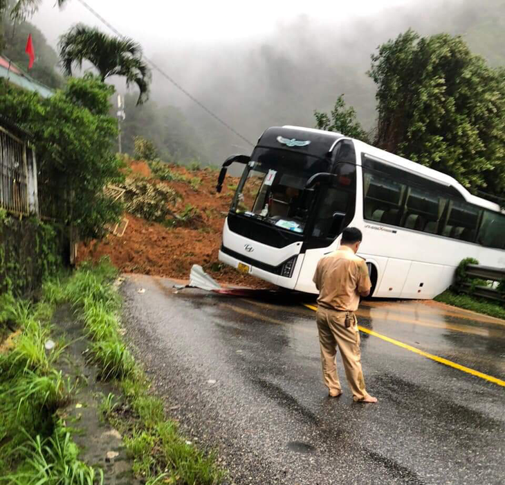 Một xe khách đi ngang qua chốt cảnh sát giao thông đèo Bảo Lộc bị đất đá đè - Ảnh: T.N.