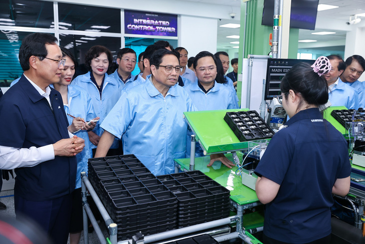Thủ tướng Phạm Minh Chính tham quan dây chuyền sản xuất thiết bị điện tử của Samsung, trao đổi với các nhân viên về tình hình sản xuất - Ảnh: Báo Chính phủ