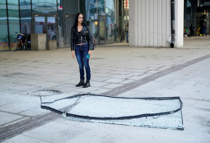 Một mảnh kính vỡ rơi xuống đường phố gần hiện trường vụ việc - Ảnh: REUTERS
