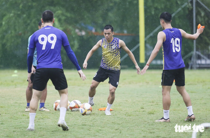 Văn Quyết và các cầu thủ CLB Hà Nội tập luyện dưới trời mưa lớn tại Hà Nội - Ảnh: ĐỨC KHUÊ