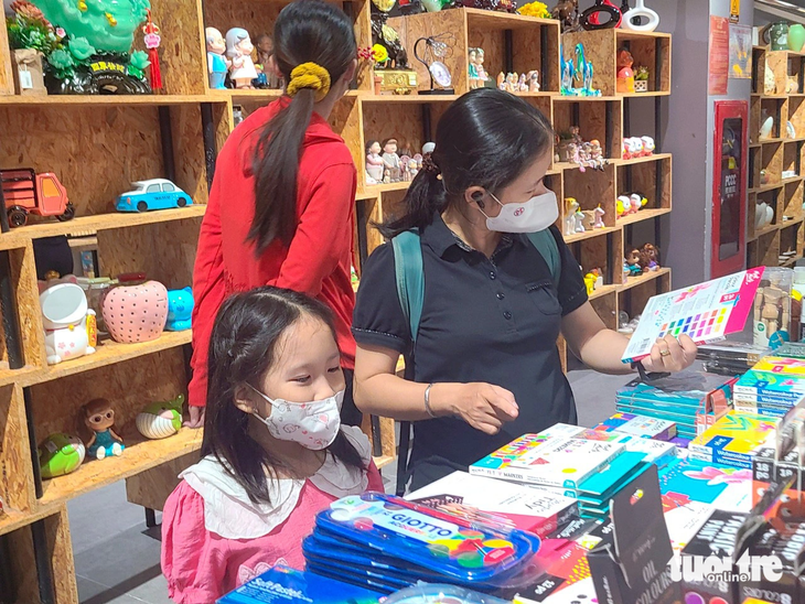 Các bạn nhỏ được phụ huynh tháp tùng đi chọn đồ dùng cho năm học mới tại nhà sách Phương Nam trong trung tâm thương mại Vạn Hạnh Mall (quận 10) - Ảnh: NHẬT XUÂN
