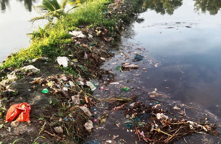 Vỡ đập bờ bao, nhiều rác thải đã tràn qua phần đất nuôi thủy sản của người dân - Ảnh: THANH HUYỀN