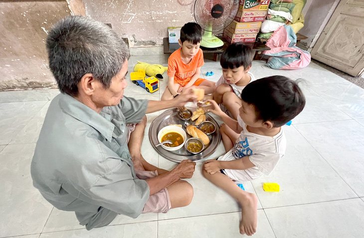 Bốn cha con bên nhau ăn phần bò kho được người ta thương cho   - Ảnh: YẾN TRINH