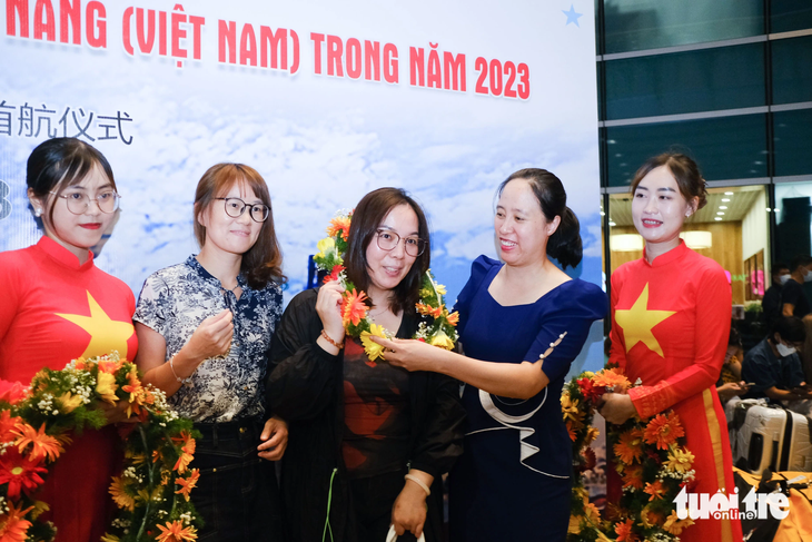 Ngành du lịch Đà Nẵng tặng hoa chào mừng đoàn khách đầu tiên từ Quảng Châu trở lại trên đường bay trực tiếp - Ảnh: TẤN LỰC