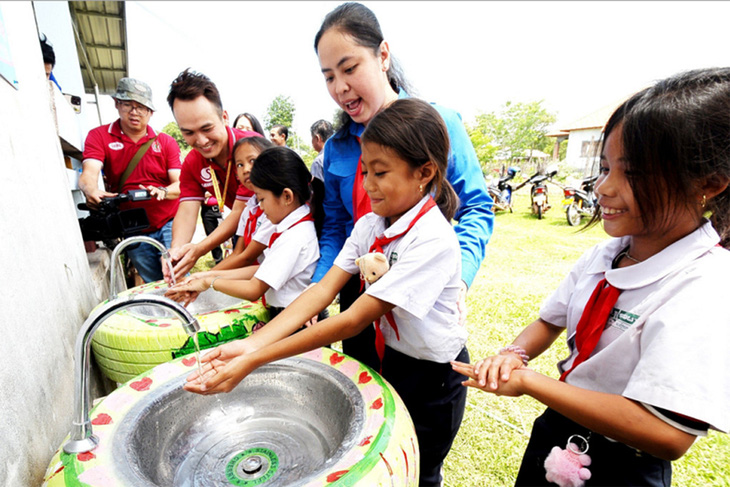 Phó bí thư Thành Đoàn TP.HCM Trịnh Thị Hiền Trân dự buổi trao tặng bồn rửa tay và hệ thống lọc nước cho trường học của Lào - Ảnh: NGUYỄN HƯNG