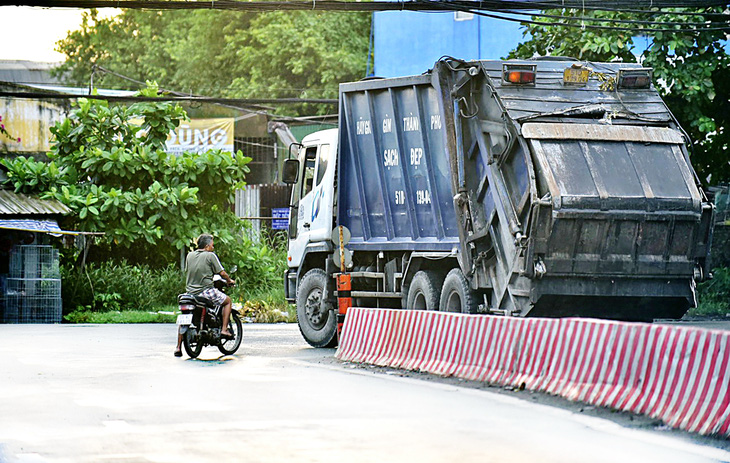 Xe lấy rác đi ngang qua khu dân cư trên quốc lộ 50, xã Đa Phước, huyện Bình Chánh - Ảnh: T.T.D.