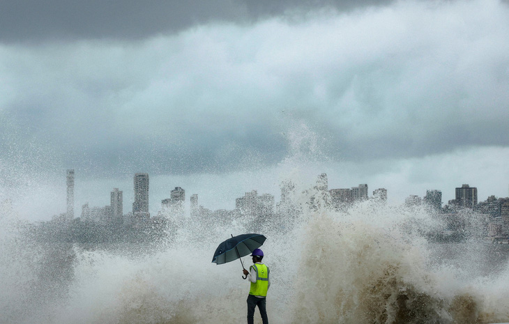 Một công nhân xây dựng đứng nhìn sóng ập vào bờ tại công trường xây dựng đường ven biển khi thủy triều lên ở Mumbai, Ấn Độ - Ảnh: REUTERS