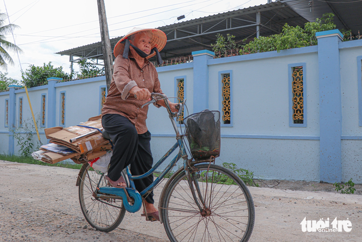Dù tuổi đã cao nhưng hằng ngày cụ Trần Thị Chích vẫn đạp chiếc xe cà tàng đi lượm ve chai để bán giúp đỡ những hoàn cảnh khó khăn - Ảnh: DUY NGỌC