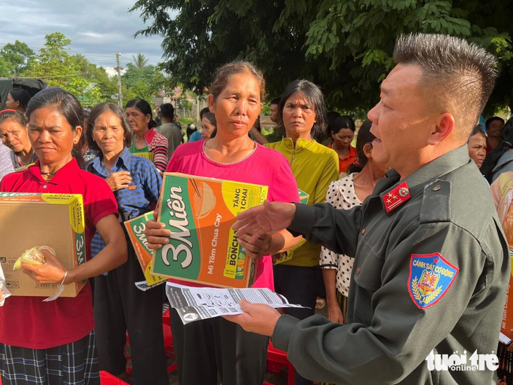 Thượng tá Nguyễn Công Hòa, trưởng Công an huyện Ea Hleo, trao quà và nhận vũ khí từ người dân - Ảnh: M.P.