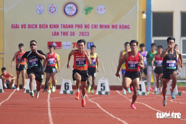Rapper Anh Phan (bìa trái) thi đấu trên đường chạy cùng vận động viên Nguyễn Văn Châu (số đeo 301) - huy chương vàng 200m Đại hội Thể thao toàn quốc 2022 - Ảnh: HOÀNG TÙNG