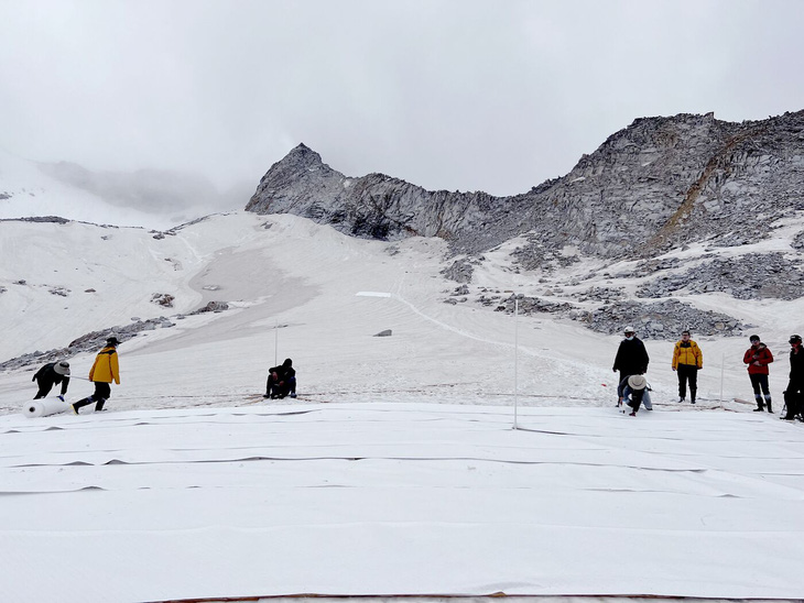 Trải những tấm vật liệu trắng trên sông băng Dagu - Ảnh: TENCENT 