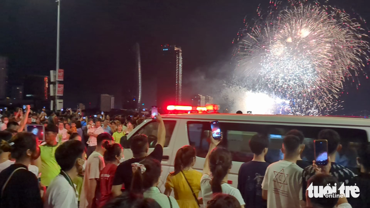 Chiếc xe cứu thương lao nhanh qua dòng người đông đúc đang xem pháo hoa trên cầu sông Hàn đêm 8-7 - Ảnh: TẤN LỰC