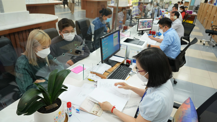 Các chuyên viên UBND quận Tân Phú (TP.HCM) giải quyết hồ sơ cho người dân - Ảnh: HỮU HẠNH