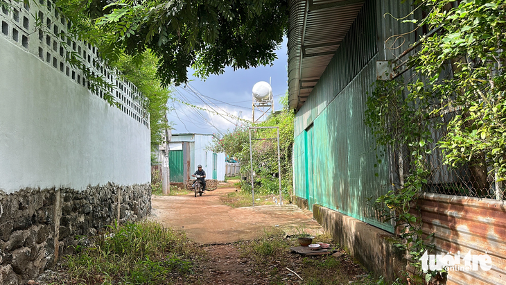 Bên kia hàng rào là bảo tàng cà phê với tiếng nhạc du dương, còn bên này nhà cửa người dân kín mít, ẩm thấp - Ảnh: TRUNG TÂN