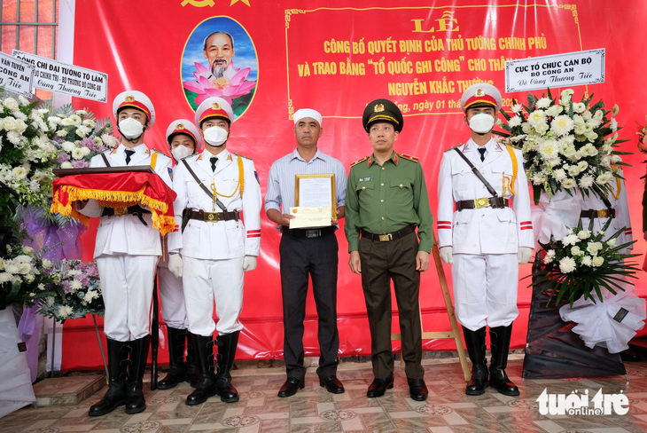 Thiếu tướng Lê Văn Tuyến, thứ trưởng Bộ Công an, đến gia đình chiến sĩ cảnh sát giao thông đã hy sinh, chủ trì và trao quyết định của bộ trưởng Bộ Công an - Ảnh: M.V.