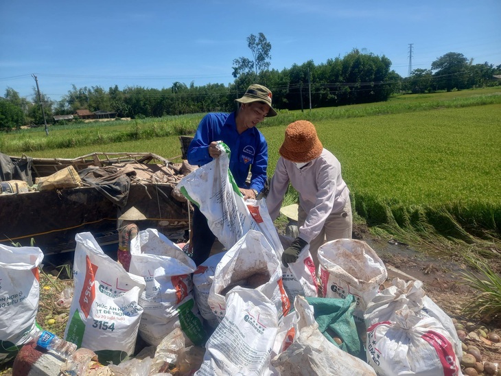 Hàng chục người dân chia nhau công việc, giúp tài xế cứu lại hàng hóa trước khi trời đổ nắng to - Ảnh: ĐPPM