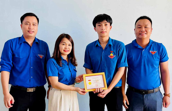 Tran Thi Thu, secretary of the Quang Tri Provincial Youth Association, presented the Brave Youth Badge to Truong Tran Tuan Kiet, a brave student who saved drowning people - Photo: Quoc Nam