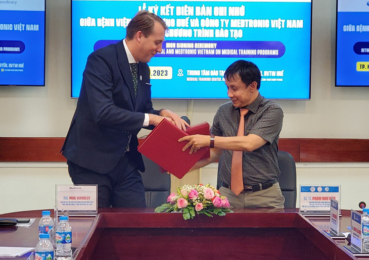 GS.TS Phạm Như Hiệp, giám đốc Bệnh viện Trung ương Huế (phải) và ông Paul Verhulst - phó chủ tịch Medtronic Đông Nam Á trao đổi biên bản hợp tác đã được ký kết