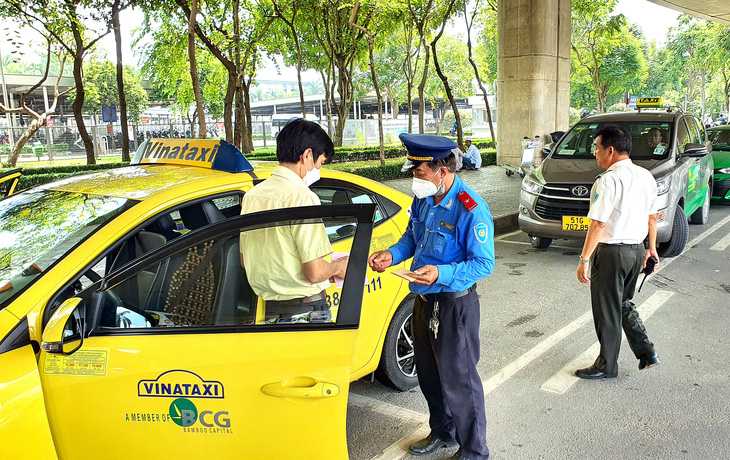 Thanh tra giao thông kiểm tra taxi khu vực sân bay Tân Sơn Nhất - Ảnh: MINH HÒA