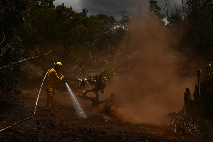 Lực lượng cứu hộ dập một đám lửa vẫn còn cháy tại khu vực đảo Maui hôm 13-8 - Ảnh: AFP