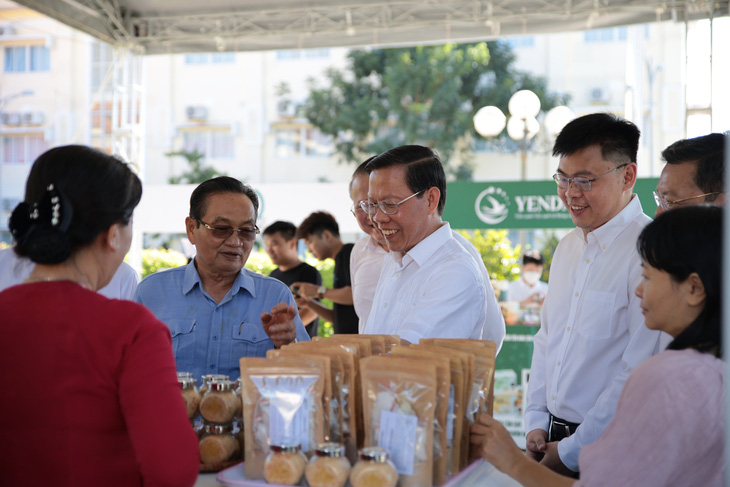 Chủ tịch Phan Văn Mãi cùng tham quan gian hàng các đặc sản ở Cần Giờ - Ảnh: TIẾN LONG