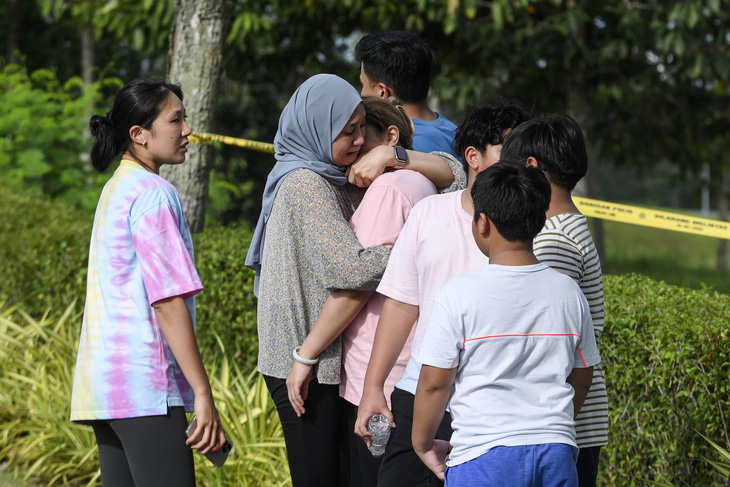 Người nhà nạn nhân đau buồn trước hiện trường vụ tai nạn - Ảnh: AFP