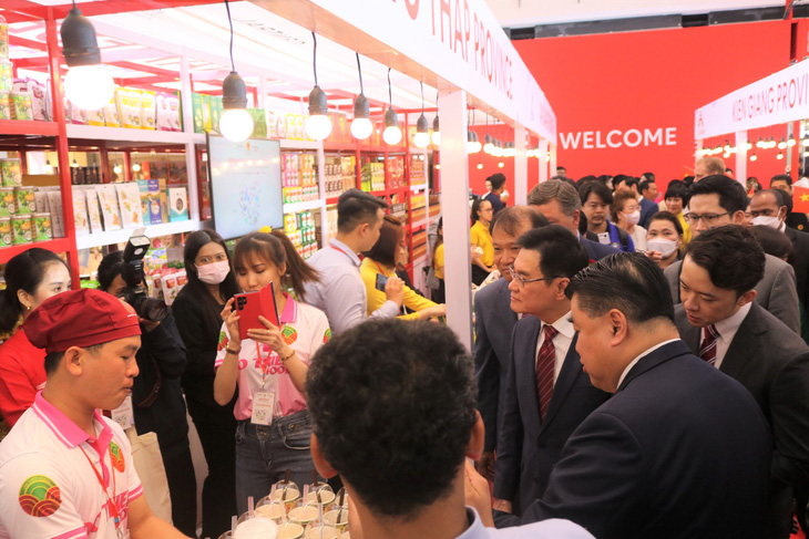 Ông Jurin Laksanawisit, phó thủ tướng kiêm bộ trưởng Bộ Thương mại Thái Lan (đeo kính), tham quan các gian hàng trưng bày của doanh nghiệp Việt Nam - Ảnh: T.T