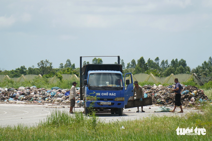 Xe đổ rác chở rác vào sân vận động huyện Ba Tri để chứa tạm vì bãi rác đang đóng cửa để khắc phục ô nhiễm môi trường 
