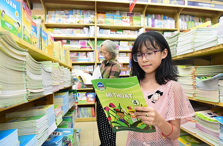 Em Mai Thảo, học sinh Trường tiểu học Kỳ Đồng (quận 3, TP.HCM), được bà dẫn đi mua sách giáo khoa để chuẩn bị cho năm học mới - Ảnh: DUYÊN PHAN