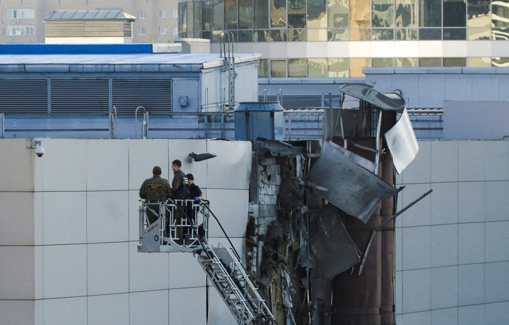 Các nhà điều tra làm việc gần tòa nhà bị hư hại sau khi một máy bay không người lái bị bắn hạ ở Matxcơva, Nga, ngày 18-8 - Ảnh: REUTERS