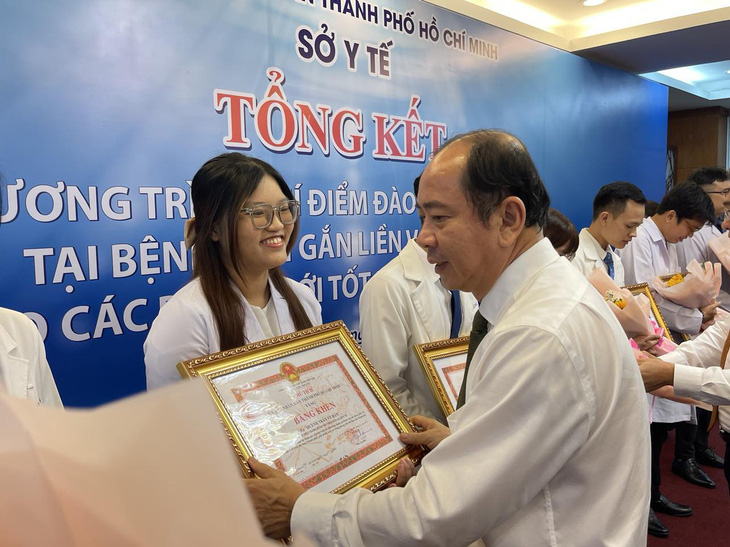 Ông Tăng Chí Thượng - giám đốc Sở Y tế TP.HCM - tặng giấy khen cho các bác sĩ trẻ xuất sắc - Ảnh: HOÀNG LỘC