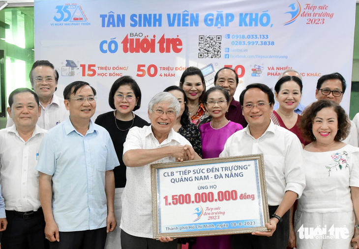 Thành viên Câu lạc bộ Tiếp sức đến trường Quảng Nam - Đà Nẵng trao bảng tượng trưng 1,5 tỉ đồng đến báo Tuổi Trẻ - Ảnh: DUYÊN PHAN