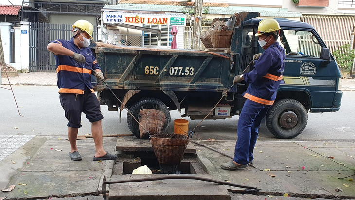 Công nhân nạo vét cống thoát nước tại quận Ninh Kiều (TP Cần Thơ) - Ảnh: LÊ DÂN