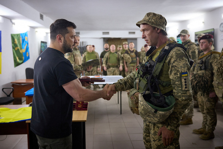 Tổng thống Ukraine Volodymyr Zelensky trao thưởng cho một binh sĩ Ukraine khi đi thăm tiền tuyến ở Zaporizhzhia ngày 15-8 - Ảnh: REUTERS