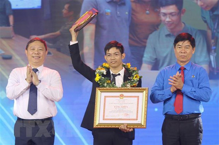 Phó chủ tịch UBND TP.HCM Dương Anh Đức (trái) và ông Phạm Chí Tâm, phó chủ tịch Liên đoàn Lao động TP, trao giải thưởng cho anh Võ Duy Phương, kỹ thuật viên Công ty Intel Products Việt Nam - Ảnh: Thanh Vũ/TTXVN