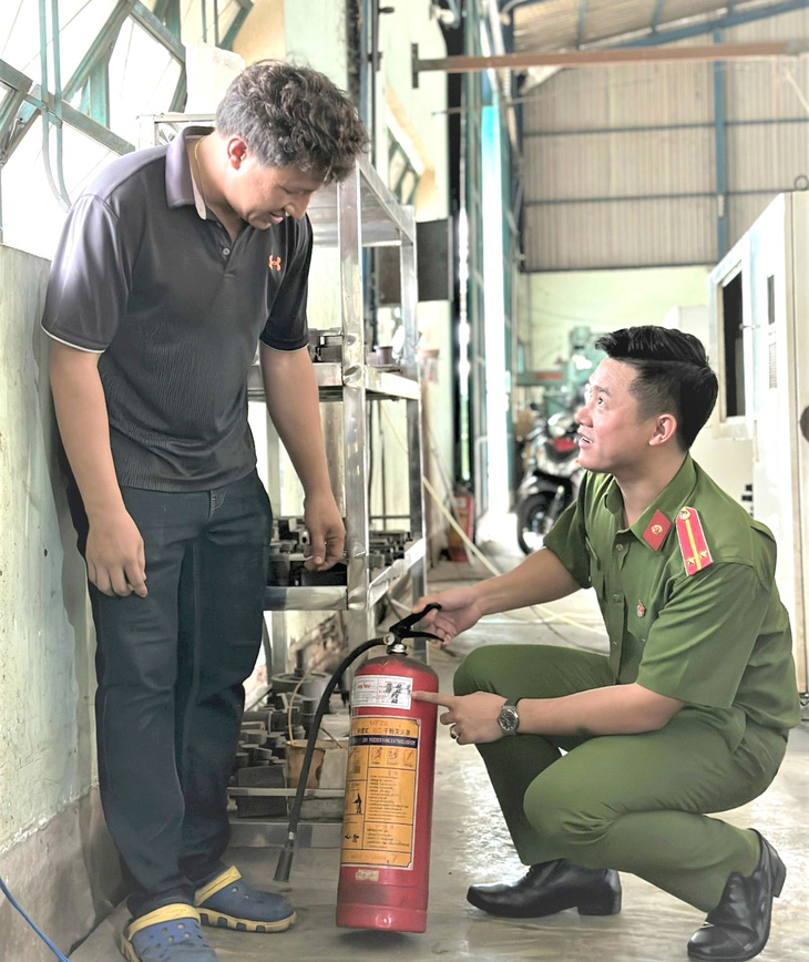 Lt. Nguyen Minh Tai instructs people to keep fire fighting equipment safe at home - Photo: NVCC