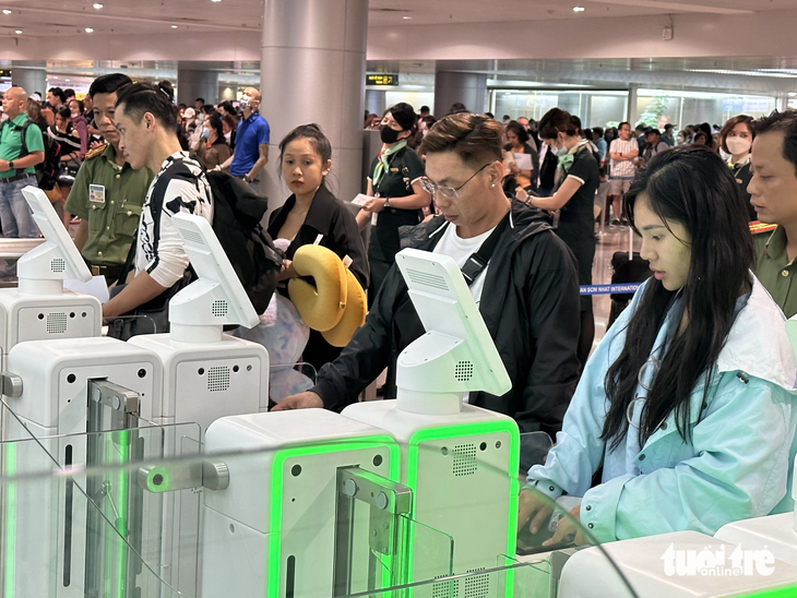 Hành khách làm thủ tục nhập cảnh tự động tại sân bay Tân Sơn Nhất. Hệ thống này lần đầu tiên được triển khai tại sân bay ở Việt Nam - Ảnh: CÔNG TRUNG