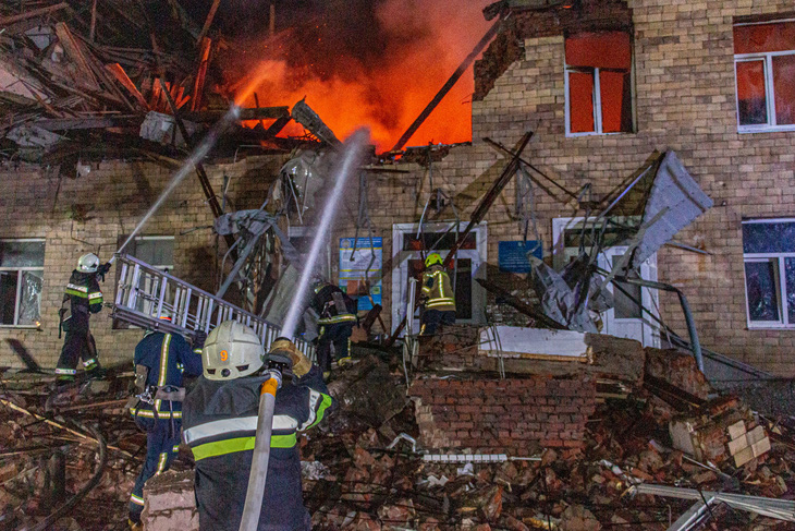 Lính cứu hỏa Ukraine cố gắng dập tắt đám cháy được cho là do drone của Nga gây ra ở Kharkov ngày 1-8 - Ảnh: REUTERS